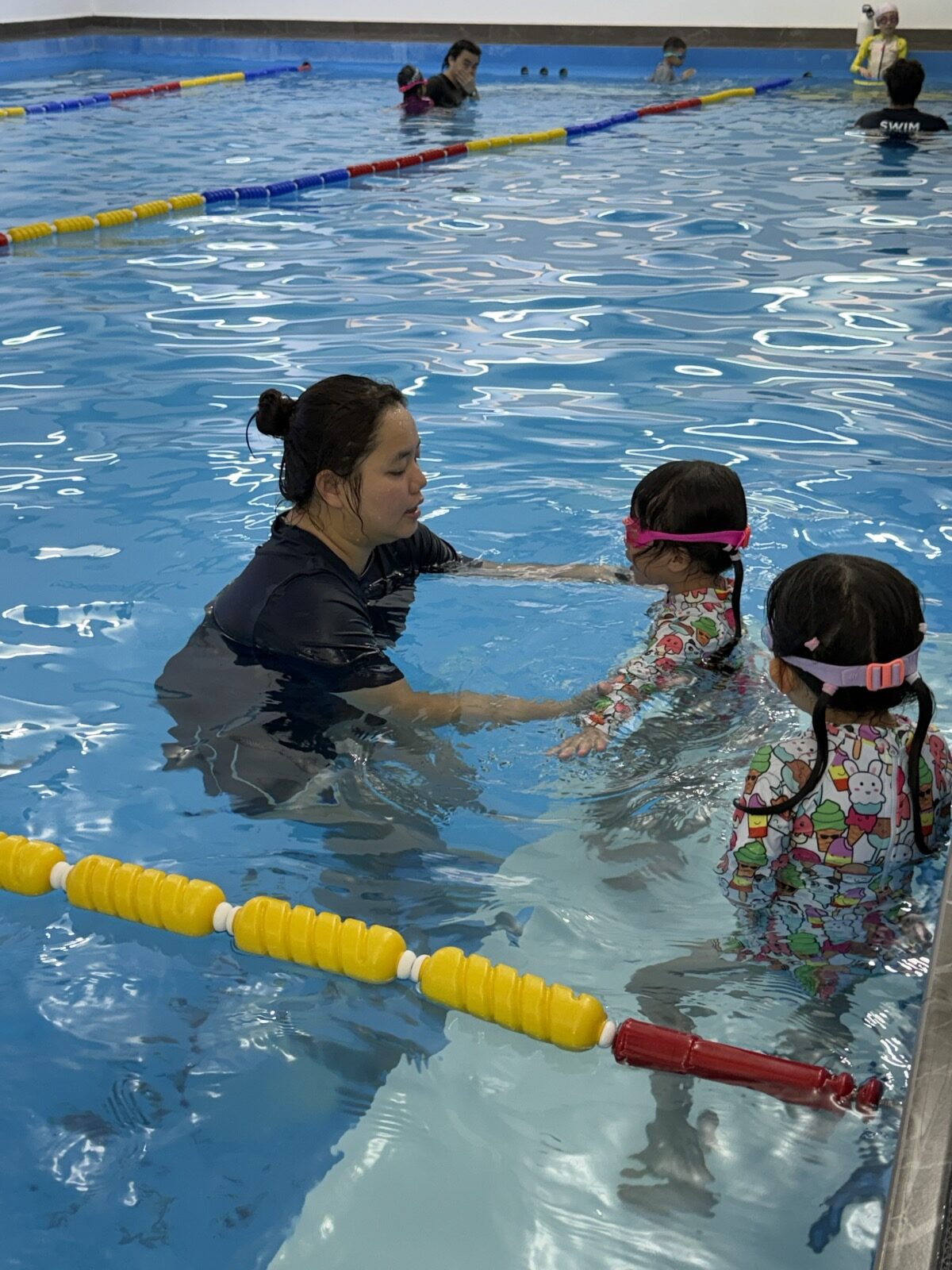Coach teaching a beginner swimmer